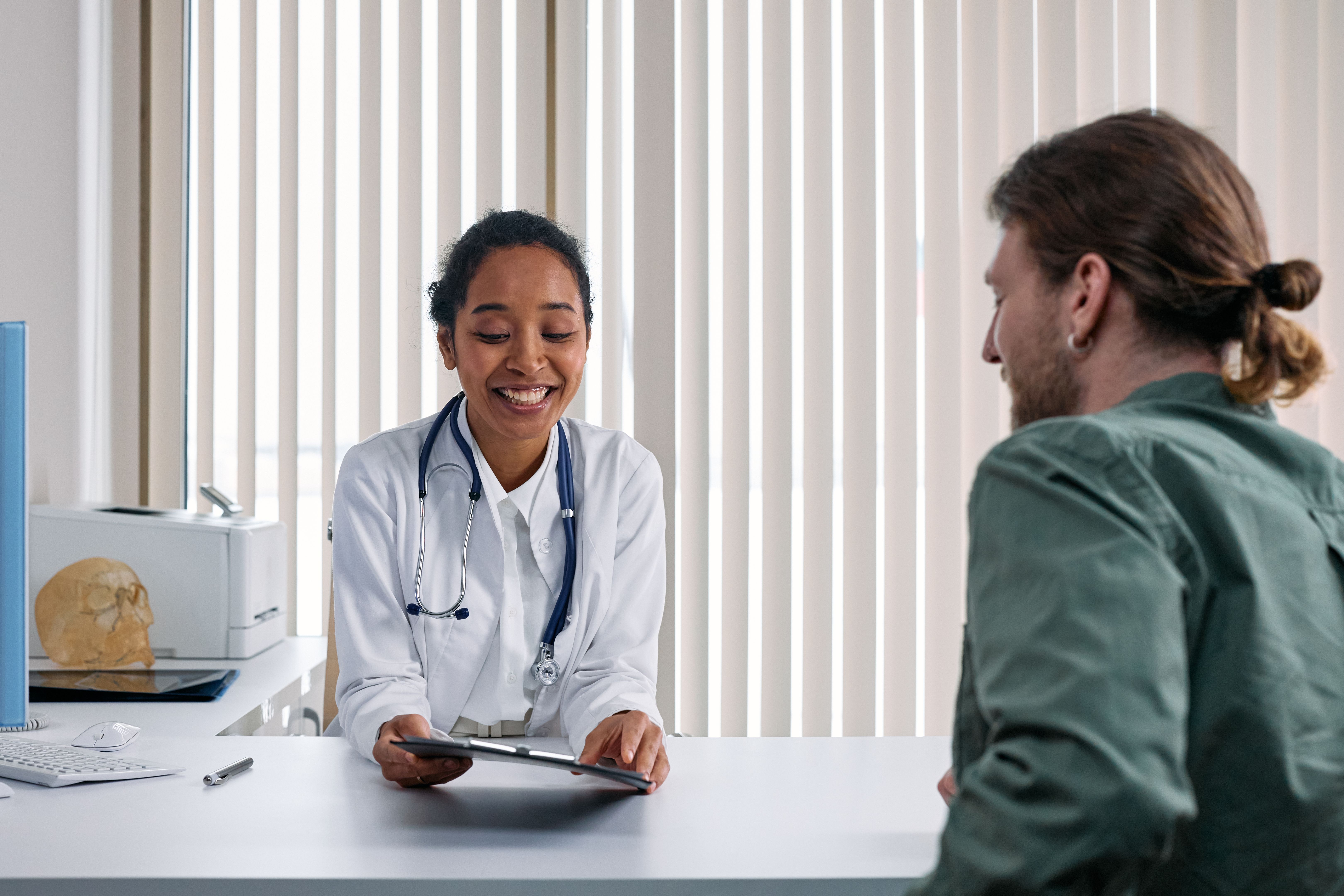 Médica conversa com paciente sobre opções de plano de saúde em consultório