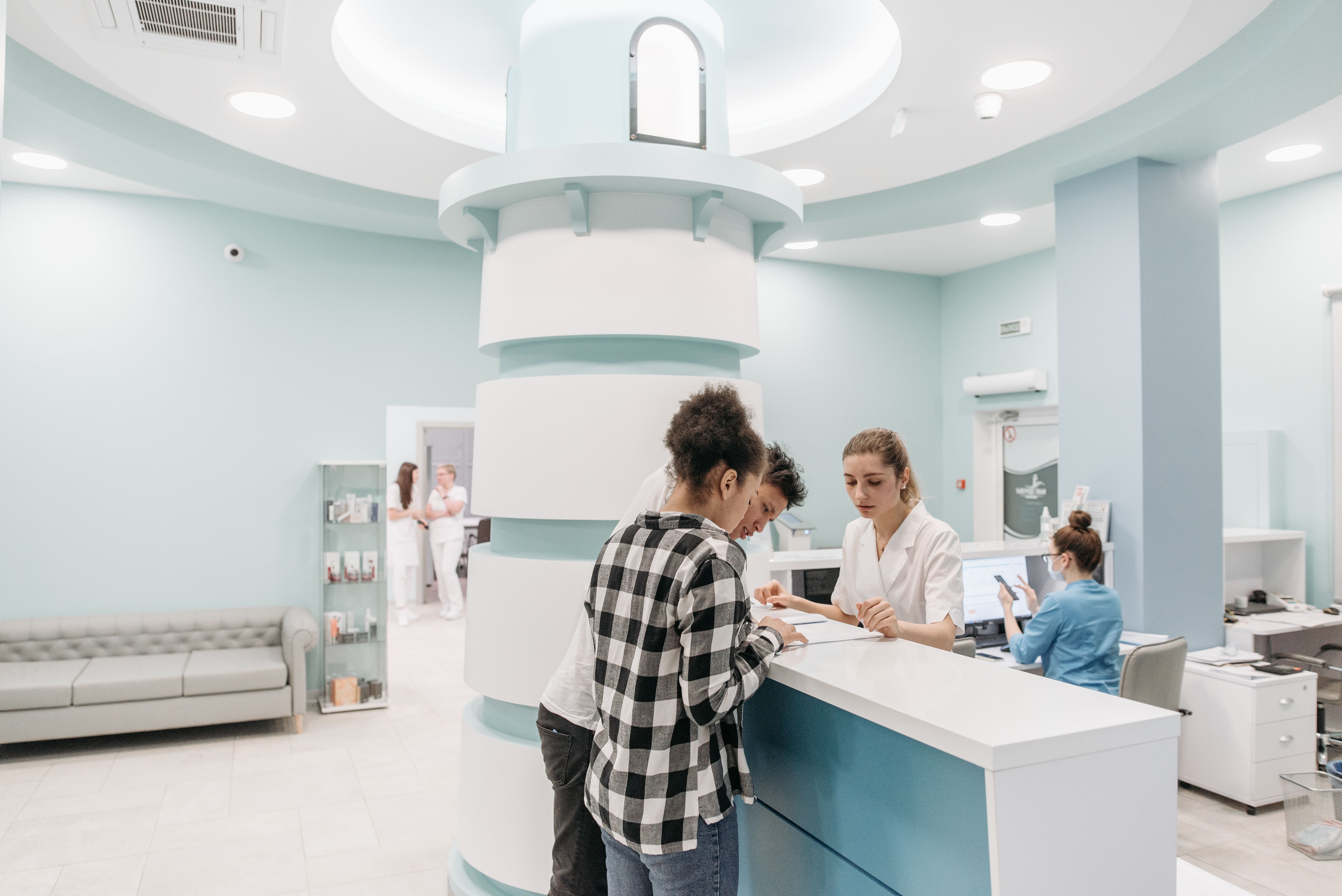 Enfermeira caminhando por um corredor iluminado de hospital da rede credenciada
