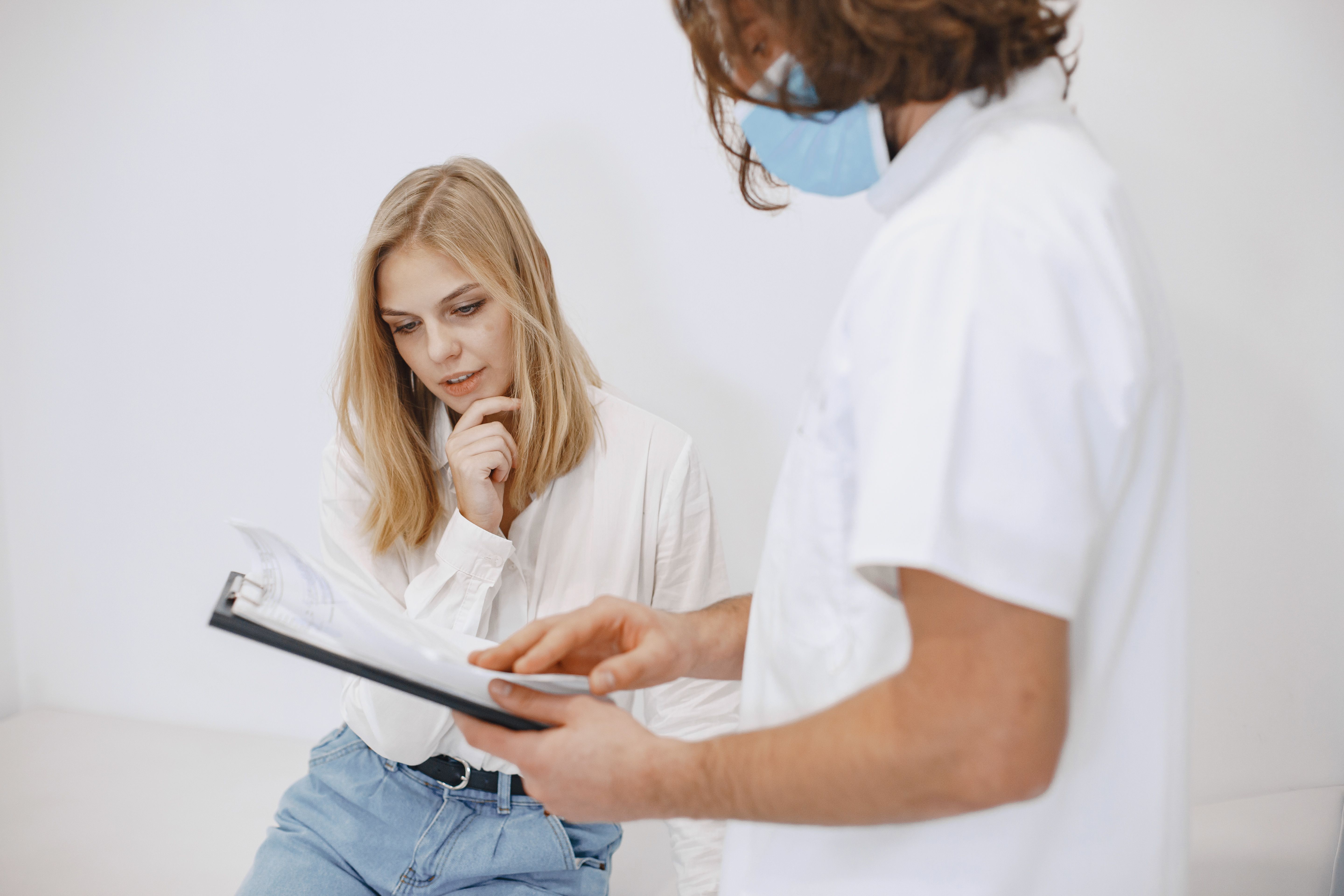 Paciente e médico olhando para uma prancheta