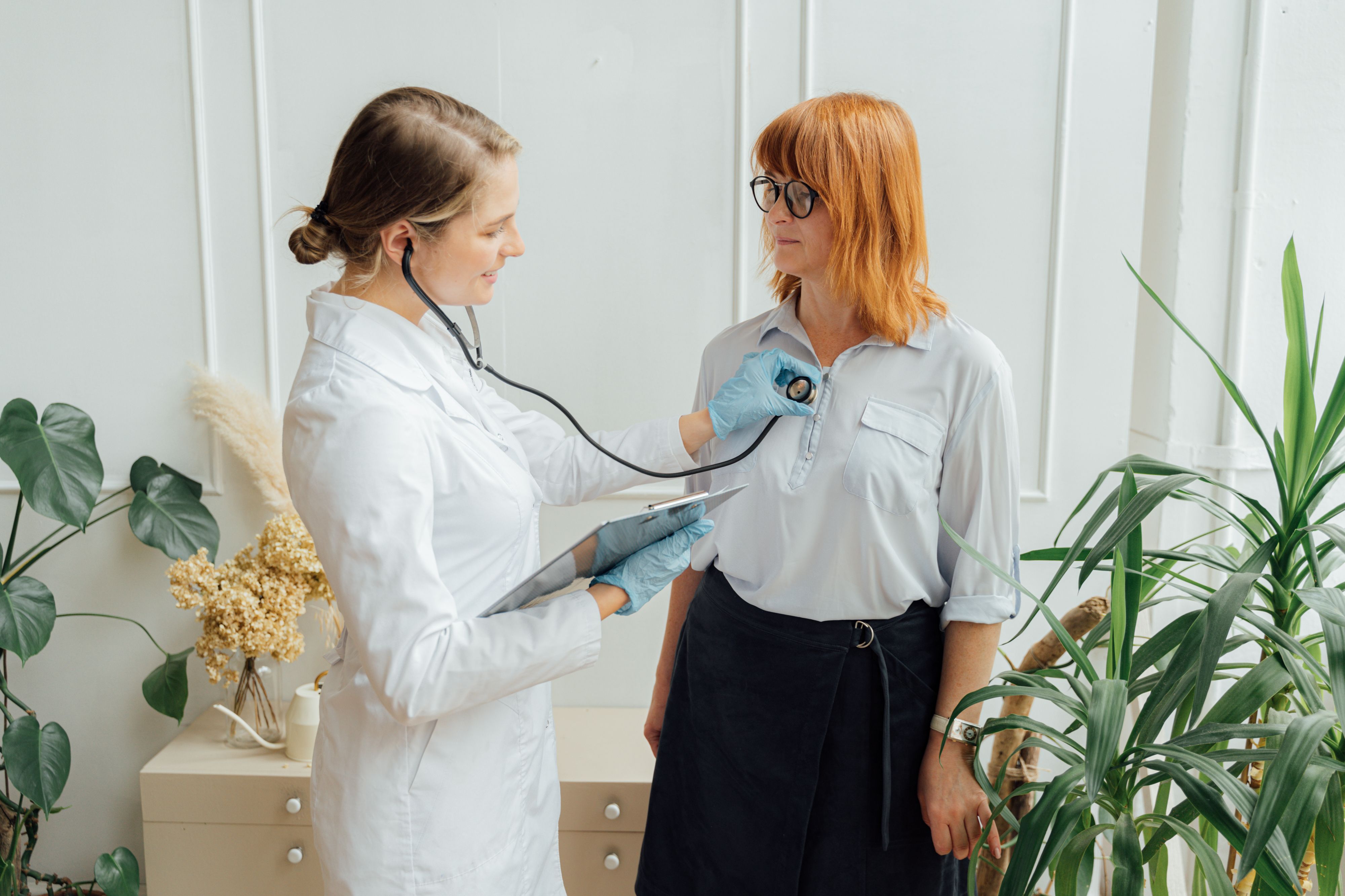 Paciente conversando com médico em consulta de rotina sobre o acompanhamento de sua condição de saúde pelo plano
