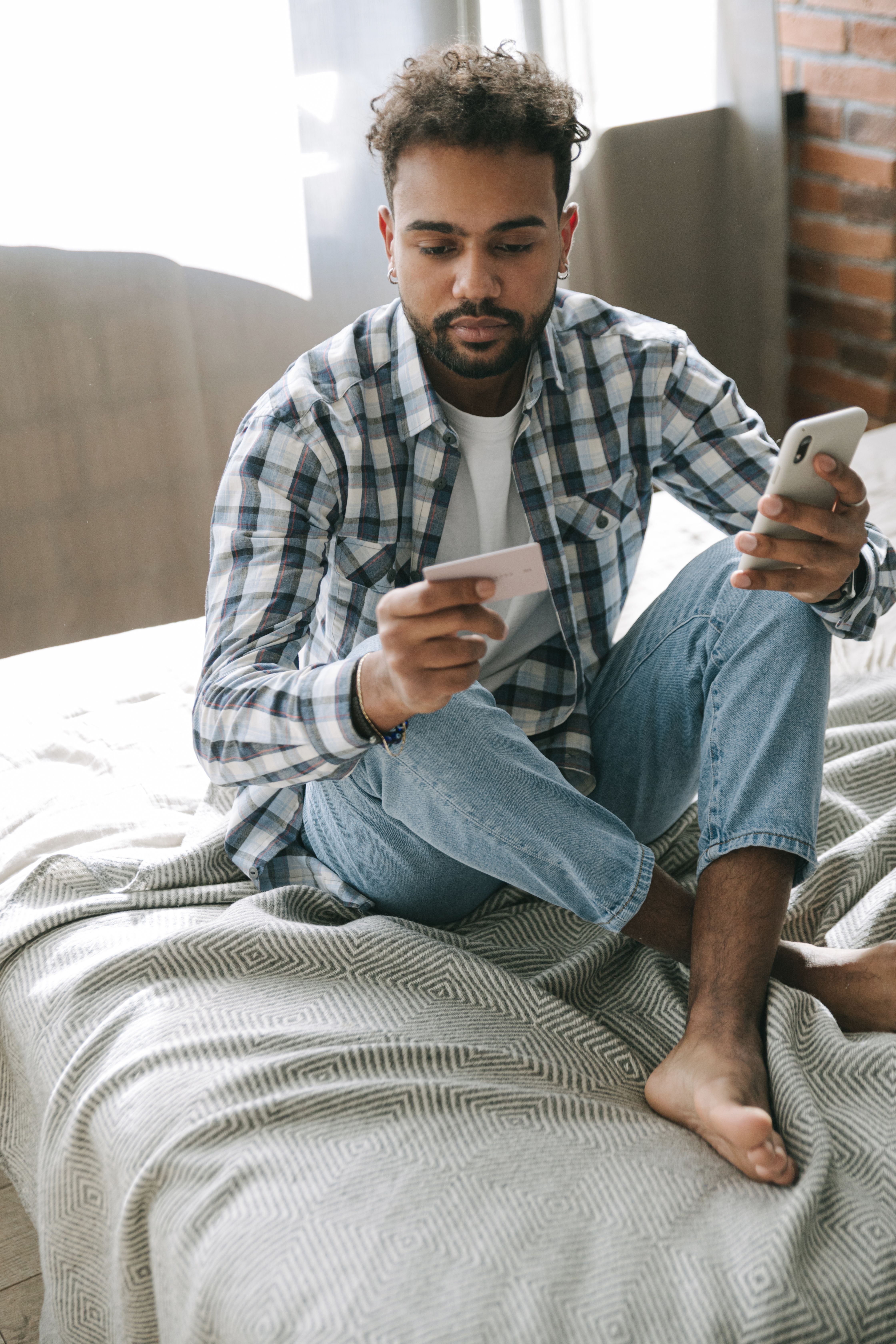 Homem com celular e carteirinha do convênio na mão ligando para a ANS