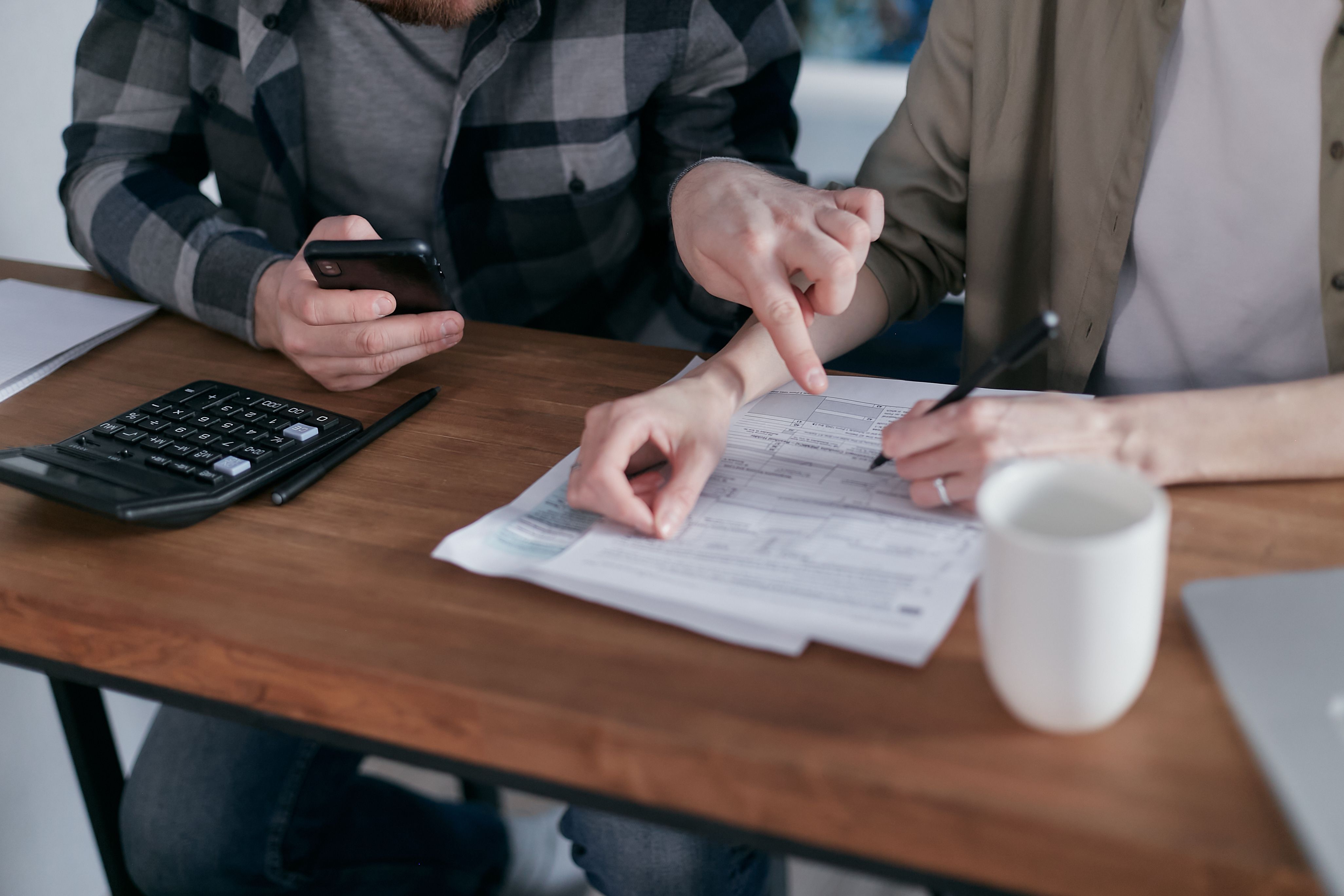 Pessoa calculando o custo mensal de um plano de saúde com coparticipação em casa