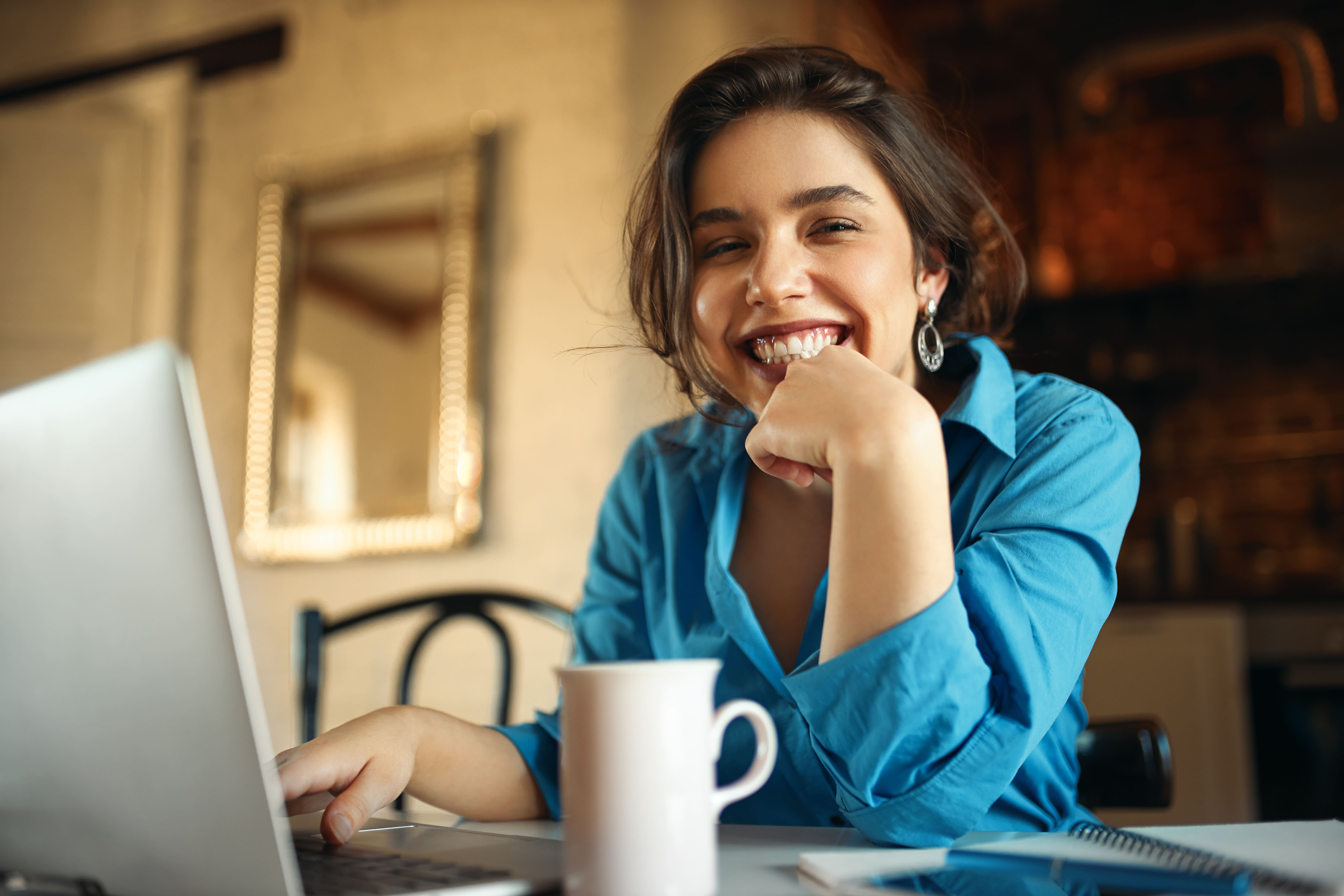 Empreendedora sorrindo ao pesquisar planos de saúde para MEI e CNPJ no notebook