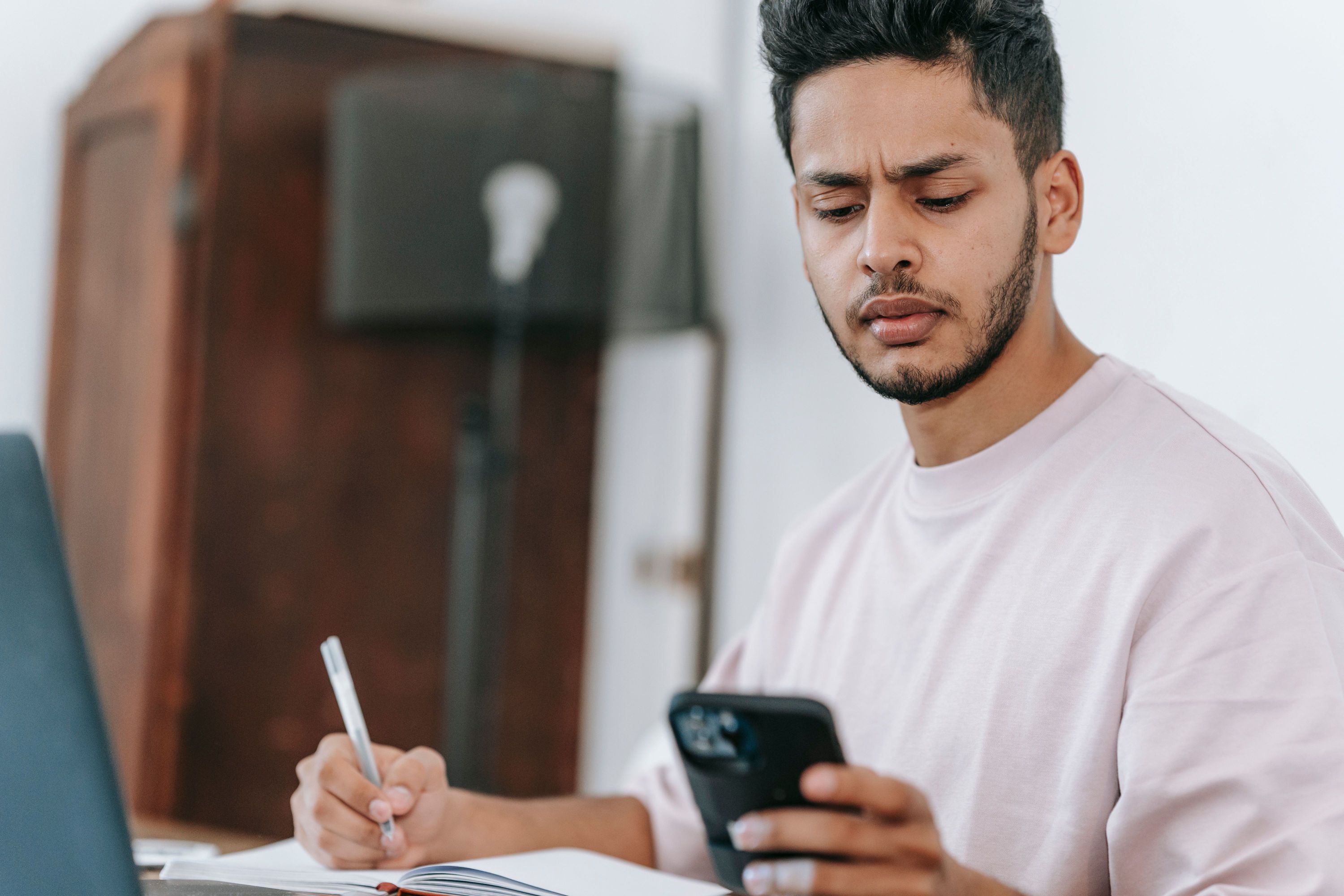 Pessoa comparando planos de saúde pelo celular com a lista dos médicos que costuma consultar