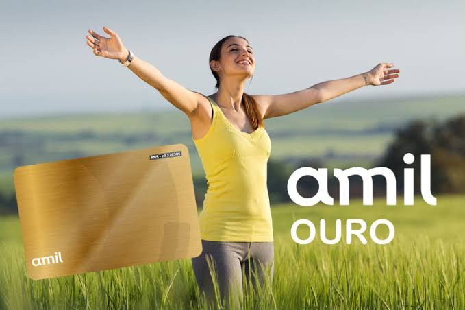 mulher com o braços abertos e uma camisa amarela em um campo, um cartão dourado do lado e o nome amil ouro